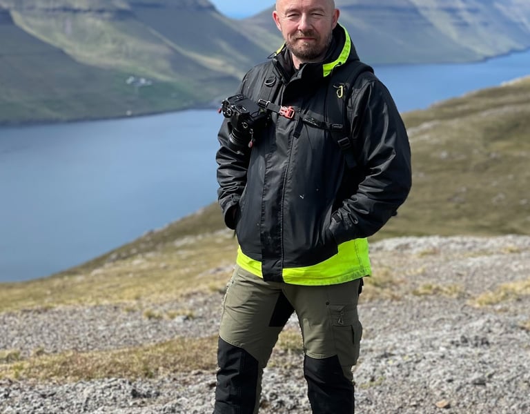 Bogi Olsen, native Faroese landscape photographer and certified tour guide, standing on a mountain i
