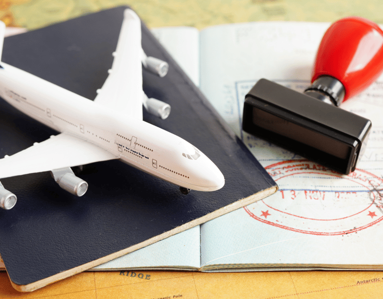 Foto representando elementos de la migración avion, pasaporte , sello