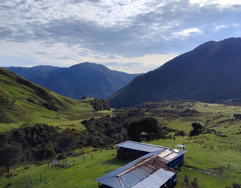 Finca campesina de alta montaña con vista al Volcán Nevado del Tolima al amanecer