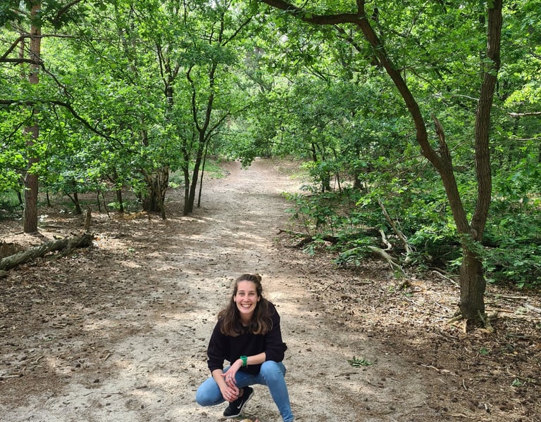 a woman and a dog sitting in the forest