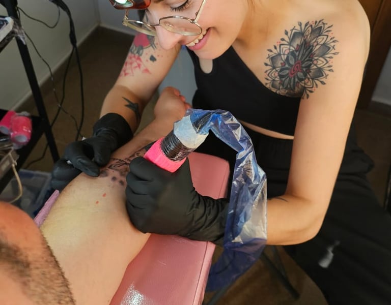 Lena, ilustradora y tatuadora trabajando en un tatuaje personalizado.