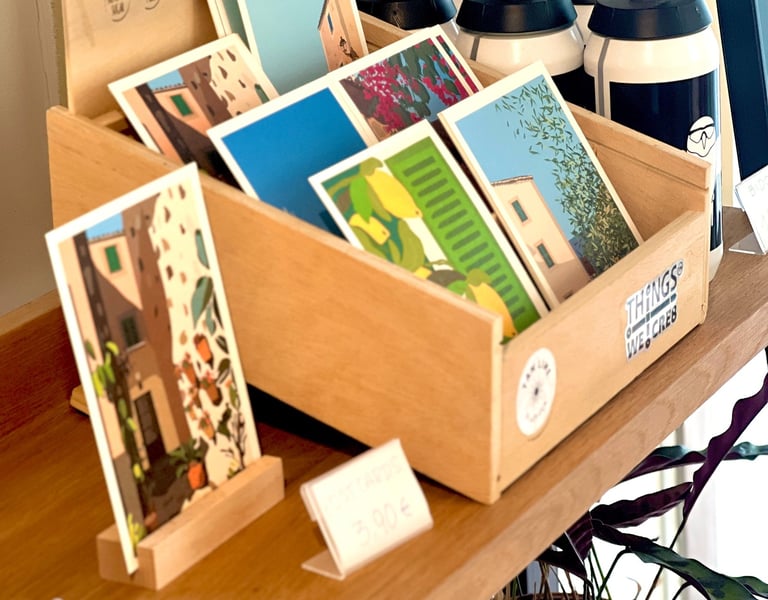 a display of postcards on a shelf designed by Carina Exner