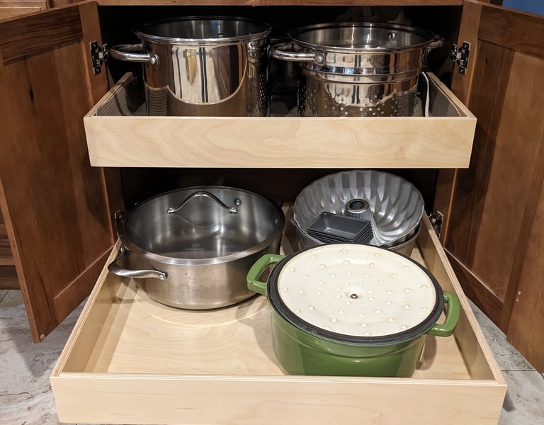 Kitchen cupboard pullouts holding pots and pans.