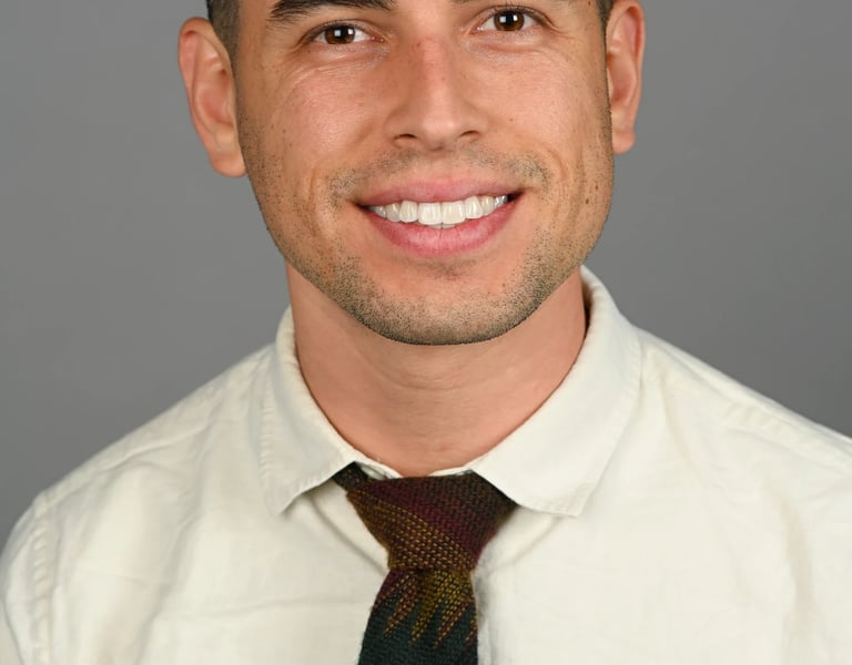Daniel Alvarez in a cream shirt and tie