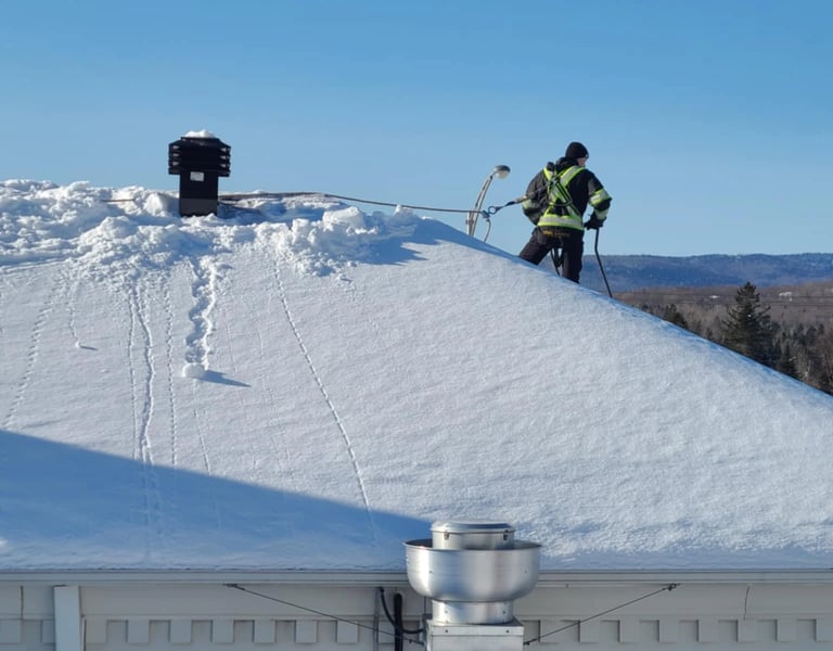 Homme qui déneige toiture avec son harnais (epi)