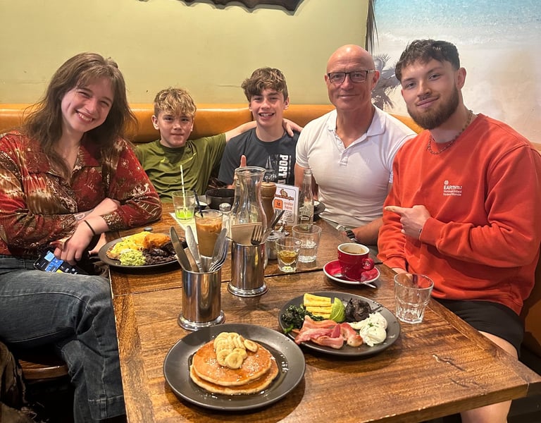 Shaun enjoying brunch with his children at a tropical-themed cafe.