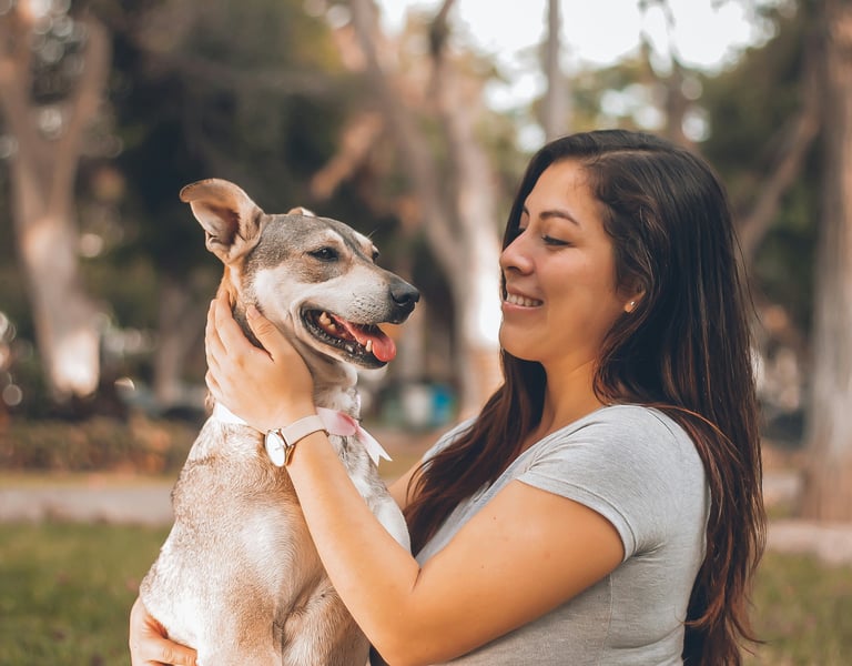 Women holding gray and white dog