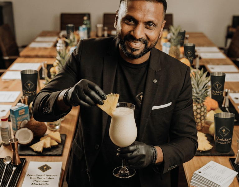 Professional bartender garnishing a tropical cocktail during a premium mixology class.