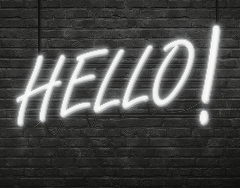 A neon lit 'Hello' on a grey brick wall