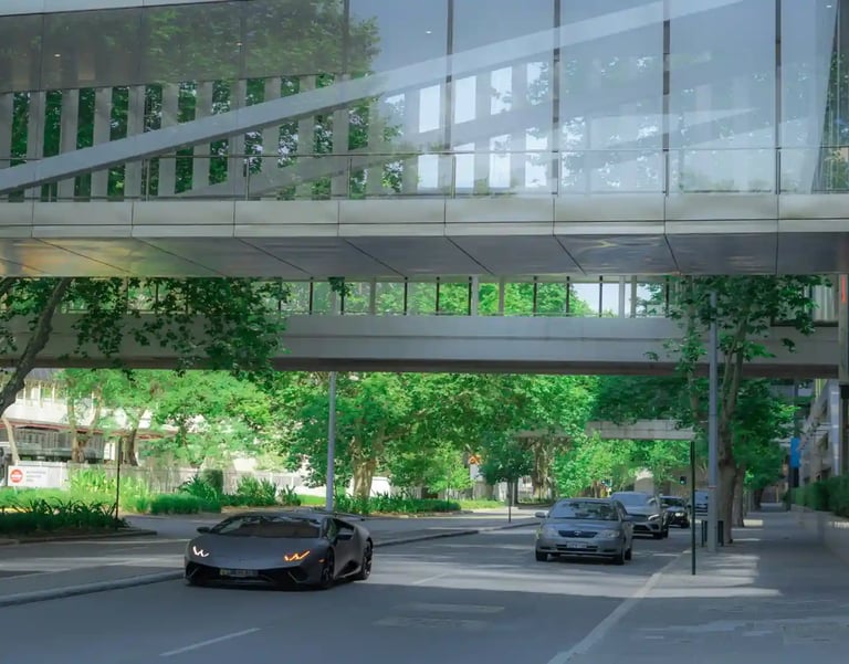 City street with modern skywalk, green trees, and cars