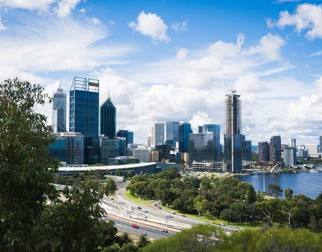 City skyline with river and greenery in foreground