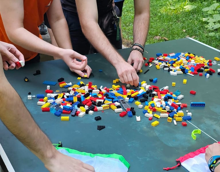 a group of people standing around a table with legos