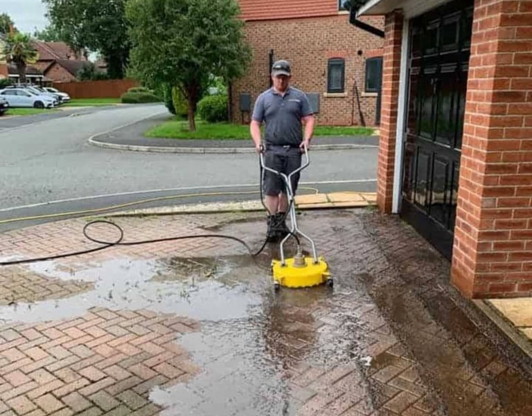 a man is using a pressurer to clean a driveway