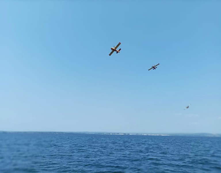 Canadair planes soar from the waters ahead of us.