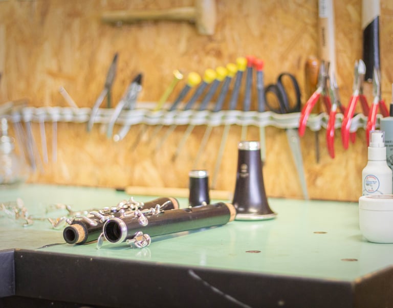 Une clarinette partiellement démontée sur l'établi du réparateur d'instruments à vent