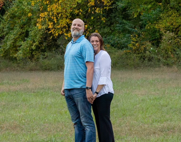RC & Dustie Mercer photo standing outside in park setting with trees in the background