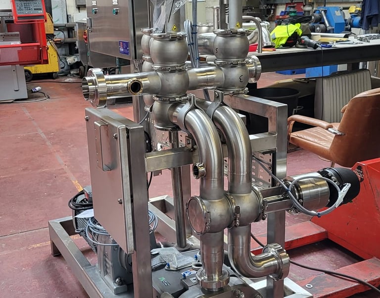 Industrial stainless steel skid-mounted pump system with control valves in a manufacturing facility.