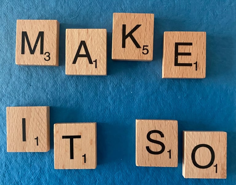 Scrabble tiles spelling out the words make it so on a blue background