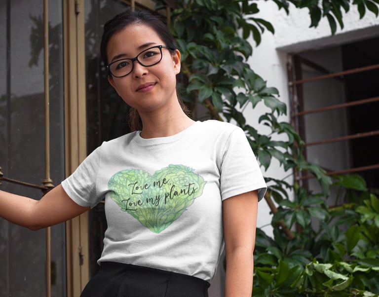 Woman wearing Miss Chatty Plants “Love Me, Love My Plants” white t-shirt with green heart design