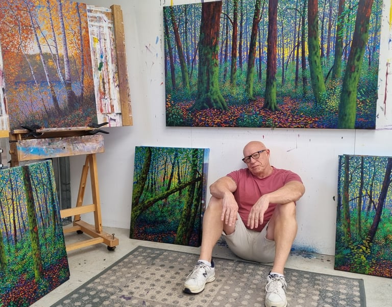 Kevin McKeown, Australian artist, sitting in his Perth studio surrounded by original abstract landscape paintings in his Chro