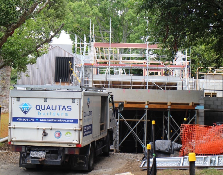 in-progress renovation project by Qualitas Builder, Auckland - truck with Qualitas Builders logo in front of scaffolding