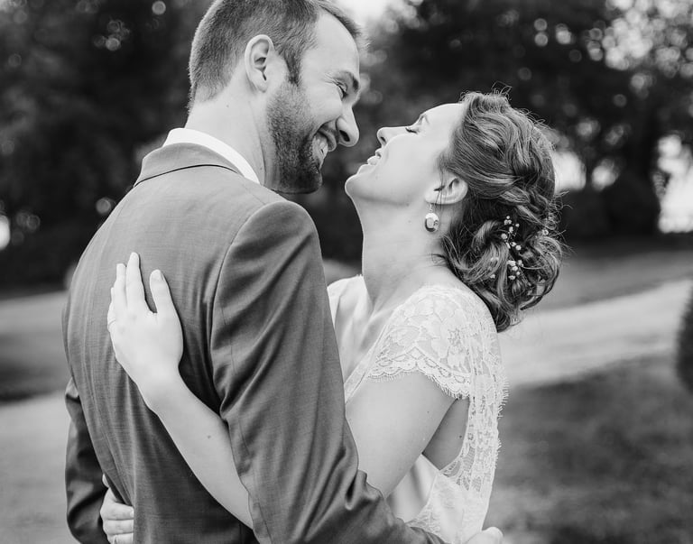 une mariée et un marié s'embrassant dans un champ