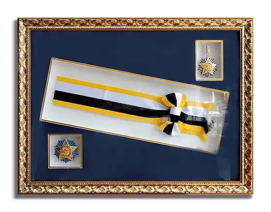 A client's important keepsakes - medals and ribbon, framed in a gold and dark blue themed frame