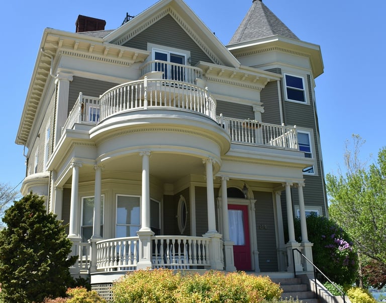 Two-story suburban home with grey siding, white trim and a red door.