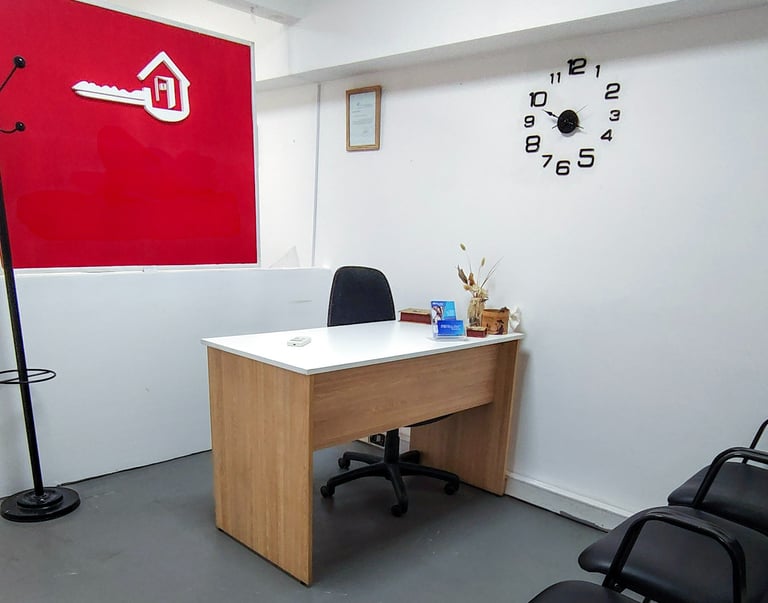 Recepción de Red de Llaves con mostrador blanco, pared roja institucional y luz natural desde el frente.