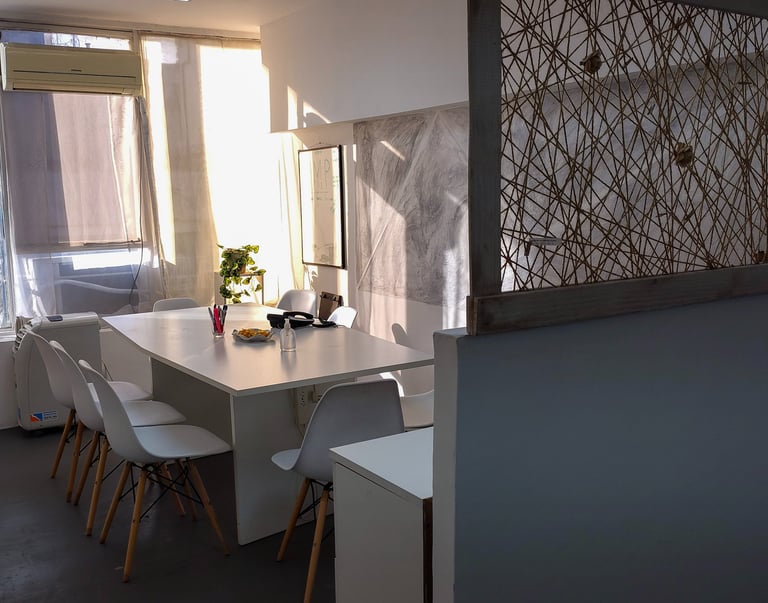 Sala de firmas en Red de Llaves con mesa blanca, luz natural y detalles decorativos sobre la cómoda.