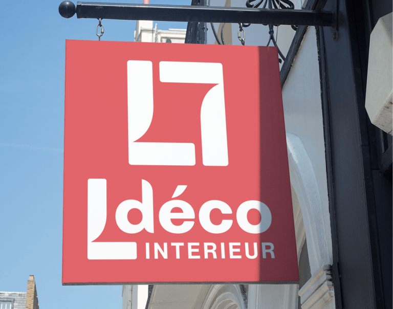 Panneau rouge suspendu pour une entreprise de design d'intérieur contre un ciel bleu
