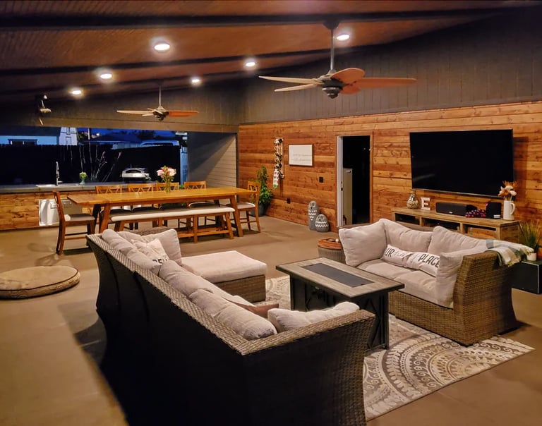 Outdoor living room and kitchen with cabin style walls and ceiling.