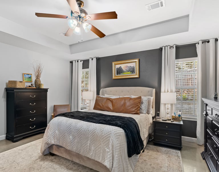 a bedroom with a bed and a ceiling fan