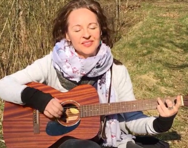 eine junge Frau - Sina Weidlich - spielt Gitarre in der Natur