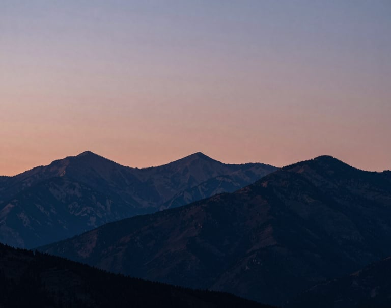 An artistic landscape of a North American / US mountain range at twilight. The sky is a gradient of dusty rose and muted blue, with the silhouettes of peaks in deep navy.
