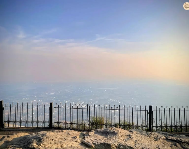 Beautiful sunset at the horizon as seen from Nandi Hills near Bengaluru, casting golden light over misty valleys and hilltops
