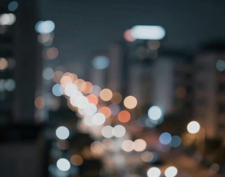 Abstract cinematic shot of blurred city lights at night, creating a soft bokeh effect in shades of #4A616F and #8C9CA6 against a dark #1A1A1A background, conveying a sense of modern motion.