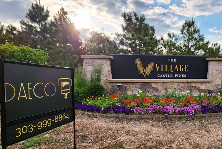 a sign that says daeco painting and sing the village castle pines