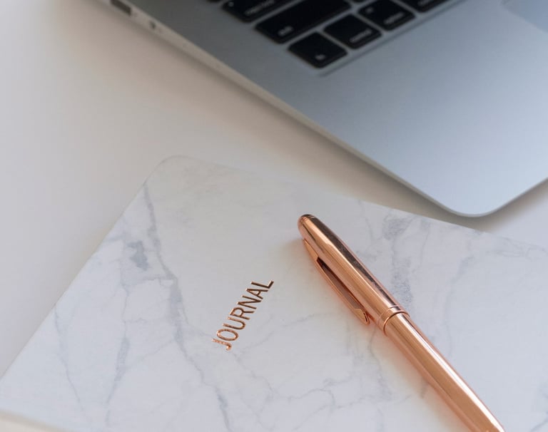 Un carnet, un stylo rose gold déposé sur un bureau attendre patiemment les notes inspirantes
