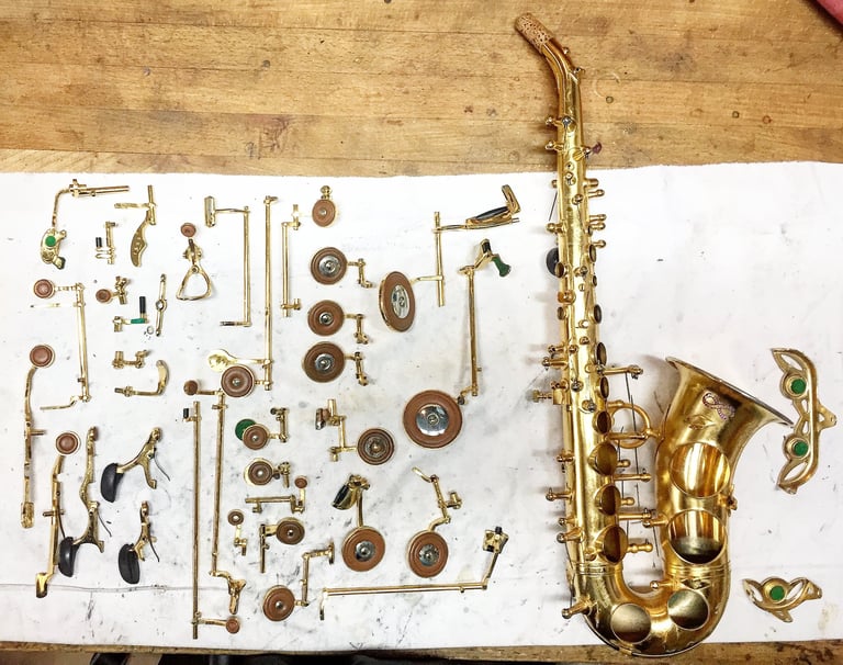 un saxophone soprano entièrement démonté avec ses clefs disposées à côté