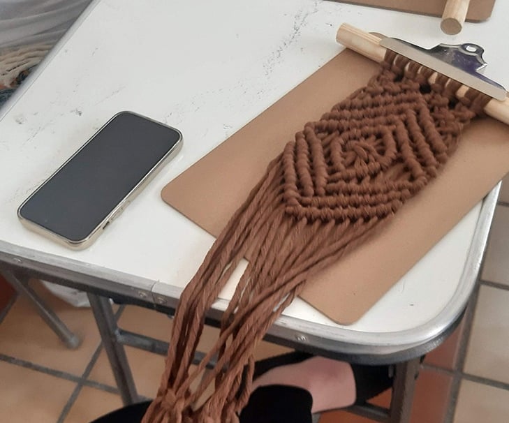 personas tejiendo a mano cordones con la técnica de macramé en un taller intermedio