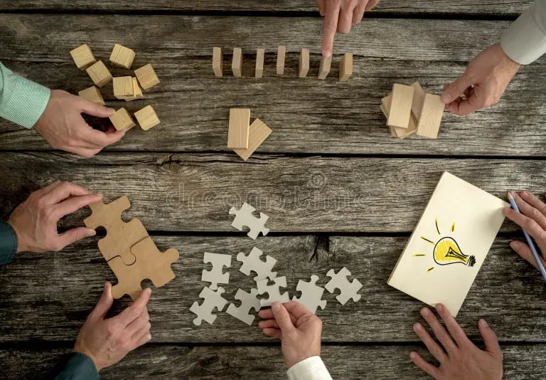 septyni dalyviai žaidžia stalo žaidimą ant medinio stalo