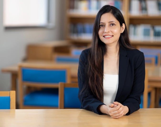 Dr Anam in black suit in library