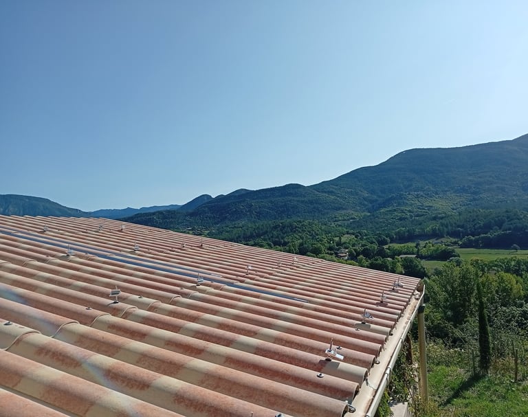 Fixations par tirfons installées sur toiture en plaques PST du carport à Mézel, préparation des rails pour panneaux solaires