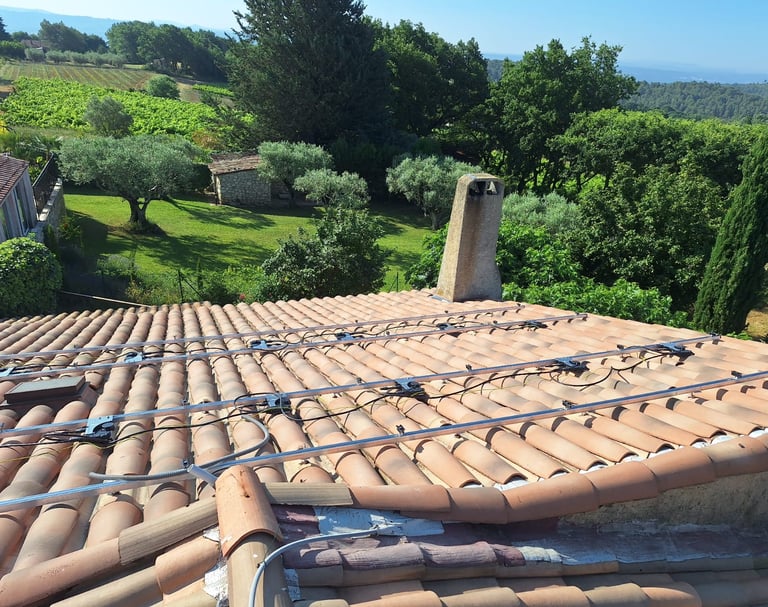 Rails, micro-onduleurs et mise à la terre installés sur la toiture à Pierrevert, avec vue sur les vignes et la forêt des Alpe
