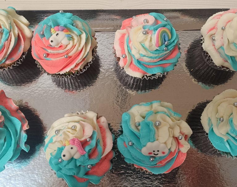 a tray of cupcakes with a teddy bear on top