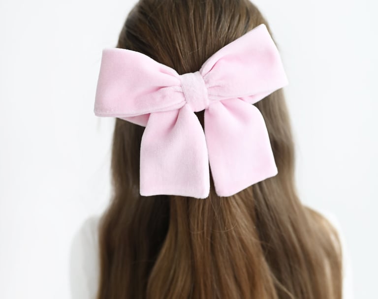 a woman with a pink bow tie on her hair