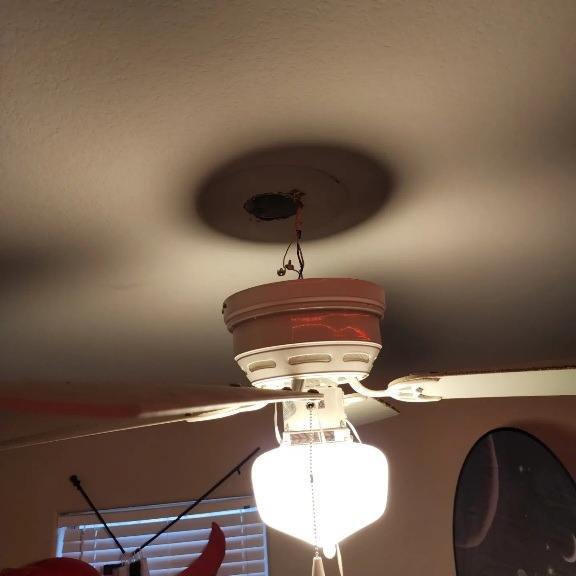 a ceiling fan with a light fixture on top of a ceiling fan
