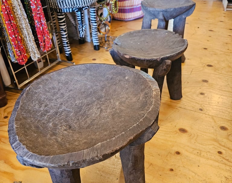 a three old wooden stools in a store