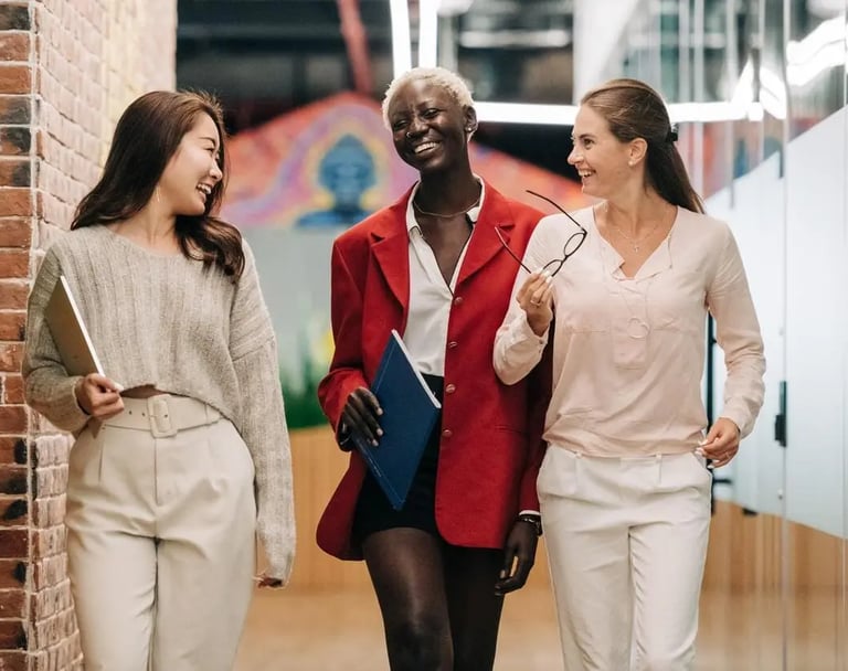 three women in business attire walking down a hallway